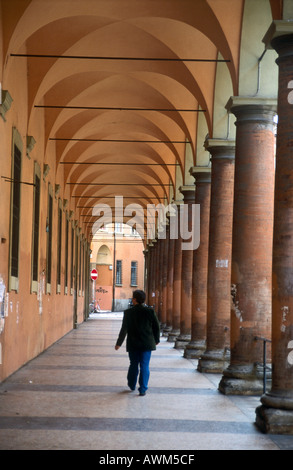 Vista posteriore di un uomo che cammina in colonnato, Università degli Studi di Bologna, Emilia Romagna, Italia Foto Stock