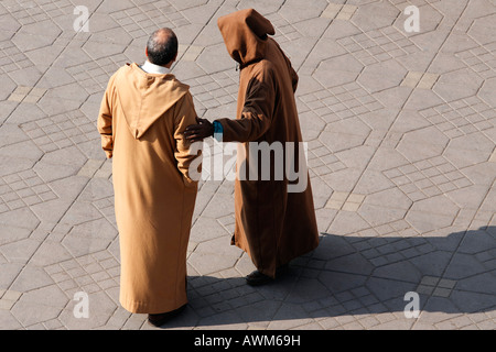 Due uomini che parlano, indossando un Djellaba, Djemaa el Fna, Marrakech, Marocco, Africa Foto Stock