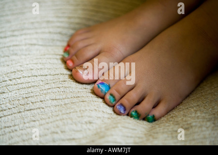 Bambina di età compresa tra i quattro anni di vernici a mano la propria toenails con punta in feltro penne Foto Stock