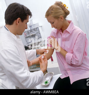 Medico maschio dando iniezione al paziente Foto Stock