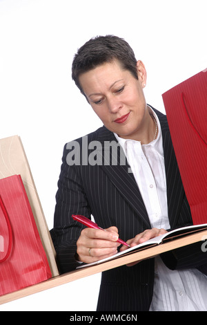 Donna che compongono la lista della spesa Foto Stock