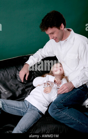 Padre e figlia tussling sul lettino Foto Stock