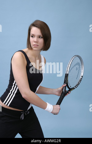 Ragazza vestita in abbigliamento sportivo oscillare una racchetta da tennis Foto Stock