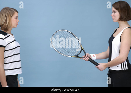 Due ragazze vestite di abbigliamento sportivo con una racchetta da tennis Foto Stock