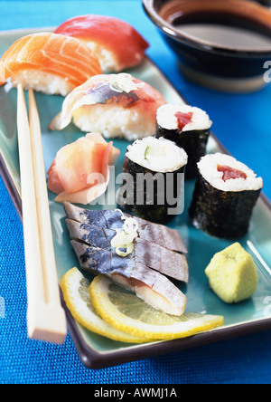 Vari tipi di sushi sulla piastra con bacchette, close-up Foto Stock
