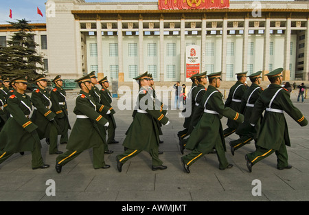 I popoli di polizia armata marzo nelle caserme passato olimpico di orologio per il conto alla rovescia al di fuori del Museo Nazionale nei pressi di piazza Tiananmen Foto Stock