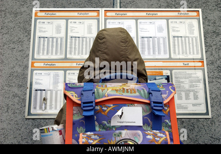 Allievo con zainetto di fronte autobus orari, Esslingen, Baden-Wuerttemberg, Germania Foto Stock