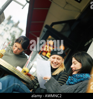 Tre ragazze adolescenti seduti al bar terrazza, inclinazione Foto Stock