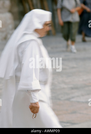 Nun a piedi in strada, vista laterale Foto Stock