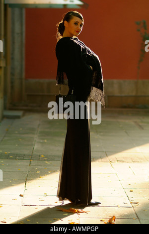 Giovane donna vestita di nero abito da sera Foto Stock