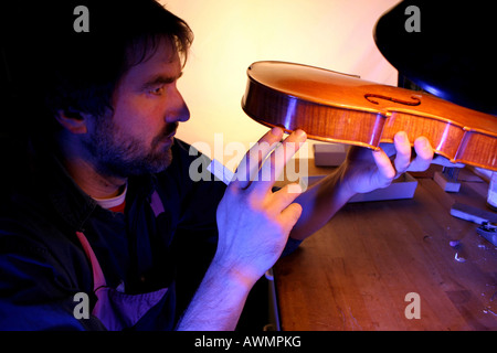 Violino-maker (liutaio) controllando la posizione del suono post Foto Stock