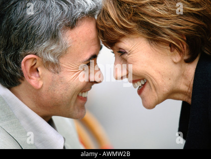 Uomo maturo e la donna guardando ogni altra toccando fronte sorridente, close up Foto Stock