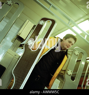 Giovane uomo che cammina attraverso il tornello cancello in metropolitana. Foto Stock