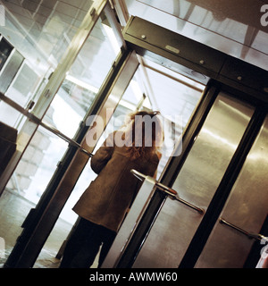 Giovane donna a piedi attraverso la stazione della metropolitana porta, vista dalla parte posteriore. Foto Stock