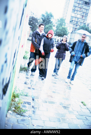 Un gruppo di giovani in cammino insieme sul marciapiede. Foto Stock