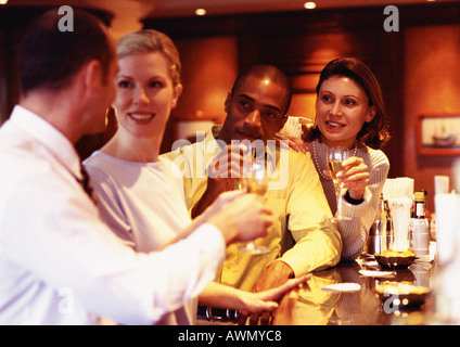 Un gruppo di persone di affari il sollevamento bicchieri al bar Foto Stock