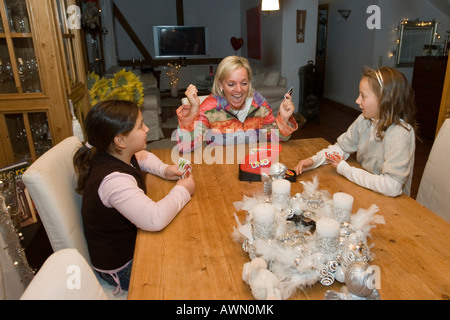 Madre giocando a carte con due dieci-anno-vecchi bambini Foto Stock