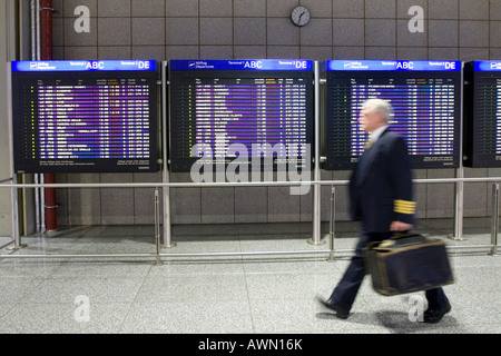 Pilota nella parte anteriore del info voli schermi di visualizzazione, terminale 2, Aeroporto di Francoforte Francoforte Hesse, Germania, Europa Foto Stock