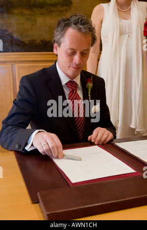 Lo sposo firma il certificato di matrimonio Foto Stock