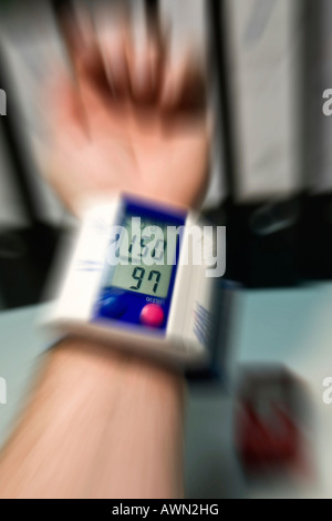 L'uomo controllare la sua pressione del sangue in ufficio Foto Stock