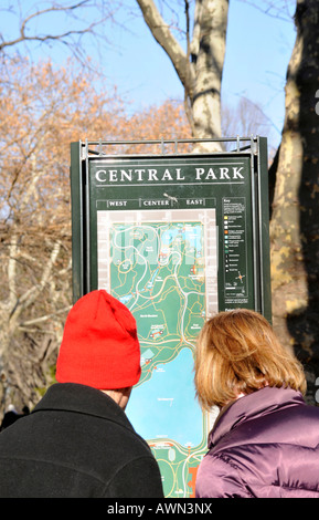 I turisti a fronte di un segnale di informazione, Central Park, Manhattan, New York, Stati Uniti d'America Foto Stock