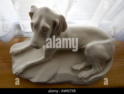 Piccola scultura di un cane bianco preso con un obiettivo grandangolare Foto Stock