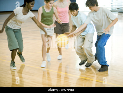 Gli studenti delle scuole superiori a giocare a basket in palestra della scuola Foto Stock