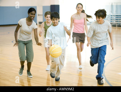 Gli studenti delle scuole superiori a giocare a basket in palestra della scuola Foto Stock