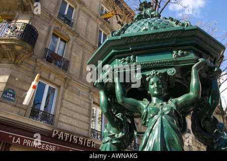 Francia Paris 18 rue Custine close up della Fontana Wallace con edificio tradizionale e pasticceria in bkgd Foto Stock