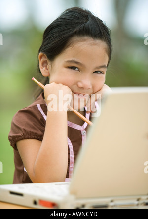 Ragazza utilizzando laptop, sorridente Foto Stock