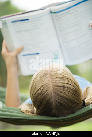 Lettura della ragazza scuola libro sull amaca Foto Stock