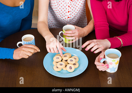 Tre donne con tè e biscotti Foto Stock