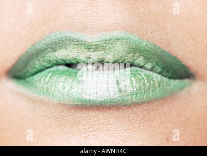 Donna che indossa un rossetto verde, in prossimità della bocca. Foto Stock