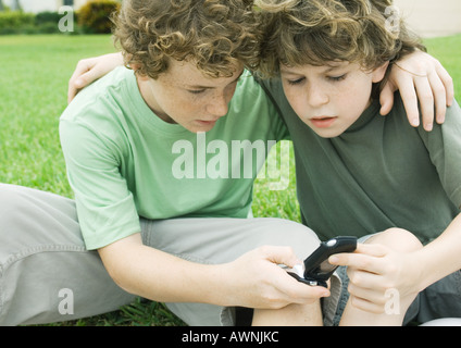 Due ragazzi guardando al telefono cellulare Foto Stock