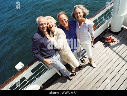 Coppie mature in piedi accanto alla ringhiera della barca, guardando la telecamera, ritratto, ad alto angolo di visione Foto Stock