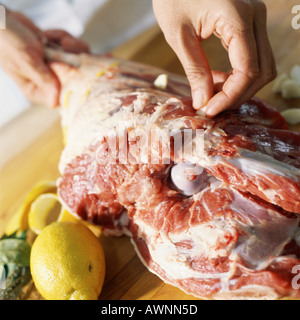 Close-up di mani preparare la gamba di agnello Foto Stock