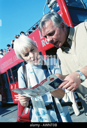 Donna matura e uomo esaminando una brochure Foto Stock