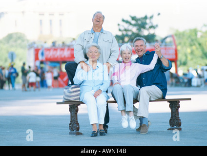 Gruppo di persone mature su un banco, sorridente in telecamera, ritratto Foto Stock