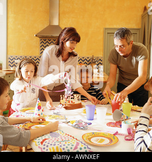 Famiglia riunita intorno a tavola per la festa di compleanno Foto Stock