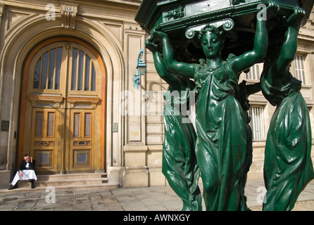 La Francia. Parigi 6. Wallace Fountain. close up con cameriere di prendere un periodo di riposo nella costruzione di cancello di ingresso Foto Stock