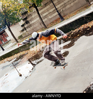 Giovane uomo a metà aria su skateboard Foto Stock