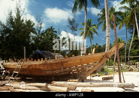 Costruzione di un tradizionale dhow di legno sulla spiaggia di Nungwi a nord-ovest di isola di Zanzibar, Tanzania Foto Stock