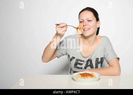 Giovane donna mangiare spaghetti Foto Stock
