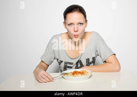 Giovane donna mangiare spaghetti Foto Stock