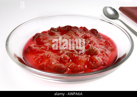 Jam di rosse bacche Mirtilli rossi su sfondo bianco in lastra di vetro ciotola Vaccinium vitis idaea mirtillo Frutta cran cibo deli nizza Foto Stock