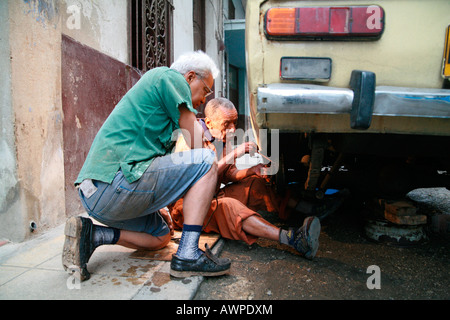 Due anziani che fissa una Lada, Havana, Cuba, Caraibi Foto Stock