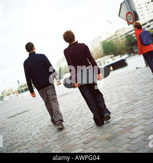 Giovani azienda skateboard, vista posteriore Foto Stock