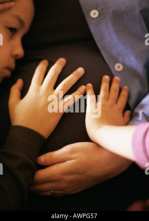I bambini di toccare la madre di stomaco in gravidanza, close-up Foto Stock