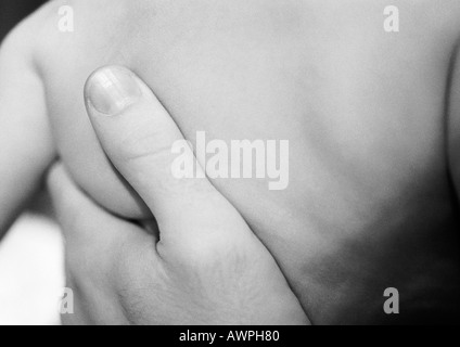 Adulto la mano sul baby torna, close-up, b&W Foto Stock