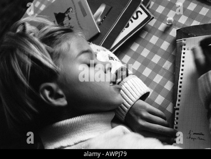 Ragazza testa di appoggio sul braccio iscritto, vista in elevazione, b&W Foto Stock